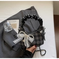 Detailansicht der karierten Hobo-Tasche mit Spitzen-Schleife und silberner Metallkette - Schwarz mit Anhänger