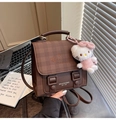 Close-up of brown vintage backpack with heart embossing and cute plush charm detail - Black (With Charm)