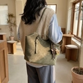 Olive green suede tote bag with bear charm shown on model in a cozy cafe setting - With Charm / Green