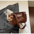 Detail of brown litchi pattern leather shoulder bag with a silver lock and bear charm - Brown with Pendant