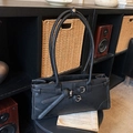 Bolso vintage negro de hombro con hebilla plateada y asas largas en un ambiente de estilo - Negro