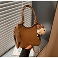 Brown lychee texture bucket bag with knot handle and plush bear charm for daily commute - Brown with Pendant
