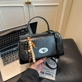 Chic black oil wax leather handbag with silver twist lock and wooden bead charm - Black