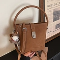 Brown bucket bag in matte synthetic leather with adjustable strap and horse charm detail - Brown with Pendant