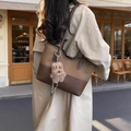 Sac cabas en toile et cuir marron avec charm chien en peluche porté par un mannequin - Marron avec pendentif