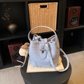 Hellblaue Beuteltasche mit Plüschwelpen-Anhänger und Metalldrehverschluss auf Tisch - Mit Anhänger / Blau