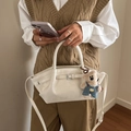 Creamy white bucket bag in soft faux leather with a cute plush bear pendant accessory - White