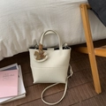 Chic beige lychee leather bucket bag with top handle, crossbody strap and horse charm - White