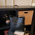 Minimalist black pebble leather bucket bag with silver buckle and adjustable shoulder strap - Black