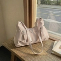 Pink patent leather tote bag with silver studs and triangle plaque on a wooden bench - Pink