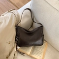 Retro dark brown crossbody bag in leather finish with white Pantoor logo on beige sofa - Brown