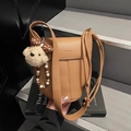 Brown litchi grain leather bucket bag with plush bear charm and crossbody strap - Brown with Pendant