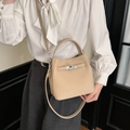 Elegante borsa a secchiello in pelle albicocca con chiusura girevole argento su modella - Albicocca