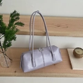 Minimalist lavender leather tote bag with dual zippers shown in a cozy lifestyle setting - Purple
