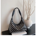Detailed close-up of a black hobo shoulder bag with silver metallic studs and rivets - Black