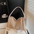 Detailweergave van kaki suède draagtas met zilveren hardware en lederen handvatten - Khaki