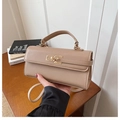 Detail of beige litchi grain faux leather handbag with gold twist lock and top handle - Khaki