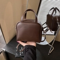 Bolso de mano minimalista en cuero marrón oscuro con correa ajustable y detalle de estrella - Marrón