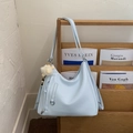 Light blue faux leather tote bag with yellow plush charm on a wooden magazine rack - Blue with Charm