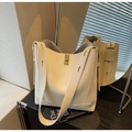 Detail of off-white lychee grain leather bucket bag with gold-tone twist lock closure - Off White