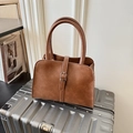 Bolso tote de cuero marrón con hebilla plateada sobre maleta para viajes de negocios - Marrón
