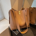 Brown leather bucket bag with pebble grain texture and gold metal buckle detail - Brown