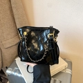 Sac bandoulière matelassé noir avec chaîne dorée posé sur une valise rétro - Noir
