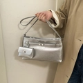 Metallic silver hobo bucket bag with a matching small coin pouch on a beige coat - Silver