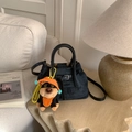Navy blue denim bucket bag with leather handles and cute dog plush charm on a sofa - With Pendant / Black