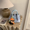 Light blue denim texture handbag with cute puppy plush charm on a stone platform - With Pendant / Blue