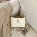 Sac à bandoulière chic en cuir beige avec boucle argentée sur un canapé - Blanc Cassé Sans Pendentif