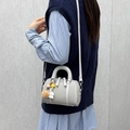 Bolso Boston gris claro con textura tejida, colgante de oso y correa de hombro ajustable - Gris