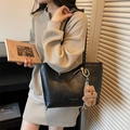 Fashionable black tote shoulder bag with a brown plush bear charm in a lifestyle setting - Black with Pendant