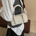 Elegante bolso Boston color crema con herrajes plateados visto en posición lateral - Blanco