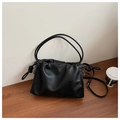 Detail of black pleated cloud bag with side knot detail on minimalist wood surface - Black