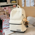 Détail d'un sac à dos en nylon blanc avec base noire contrastée et pendentif peluche - Beige Avec Charme