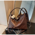 Detail of vintage brown leather tote bag showing soft texture and bear ornament - Brown
