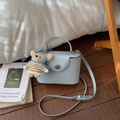 Détail du sac boîte bleu clair avec fermoir rotatif et charmant ours en peluche - Bleu avec Pendentif