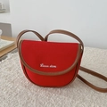Chic red canvas saddle bag with brown leather trim and adjustable crossbody strap - Red
