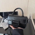 Detail view of black glossy leather handbag with square buckle and top handle - With Charm / Black