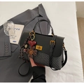 Détail du sac vintage avec tissu texturé, fermoir doré et pendentifs fleurs élégants - Noir (avec pendentif)