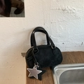 Dettaglio borsa Boston in camoscio nero con manici e ciondolo a stella su legno - Nero