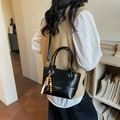 Chic black leather bucket bag with top handles and colorful beaded charm detail - Black With Pendant