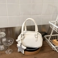 Dettaglio della borsa Boston bianca con rilievo e ciondolo a stella in ambiente cucina - Bianco