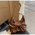 Detail der karamellbraunen matten Ledertasche mit Schleife und weißem Spitzenrand - Braun