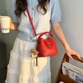 Red lychee grain leather bucket bag with gold lock and plush bear charm detail - Red with Pendant
