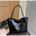 Detail of black faux leather tote bag with large front pocket and long shoulder straps - Black