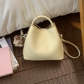 Bolso cubo chic de cuero beige con colgante de perro y correa en suelo de madera - Con Colgante / Amarillo