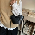 Schicke schwarze Eimertasche aus Kunstleder mit Cut-out-Griff und silbernem Metallanhänger - Schwarz