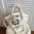 Beige lychee lederen bucket bag met zilveren draaisluiting en konijntjeshanger - Rijstwit (Met Hanger)